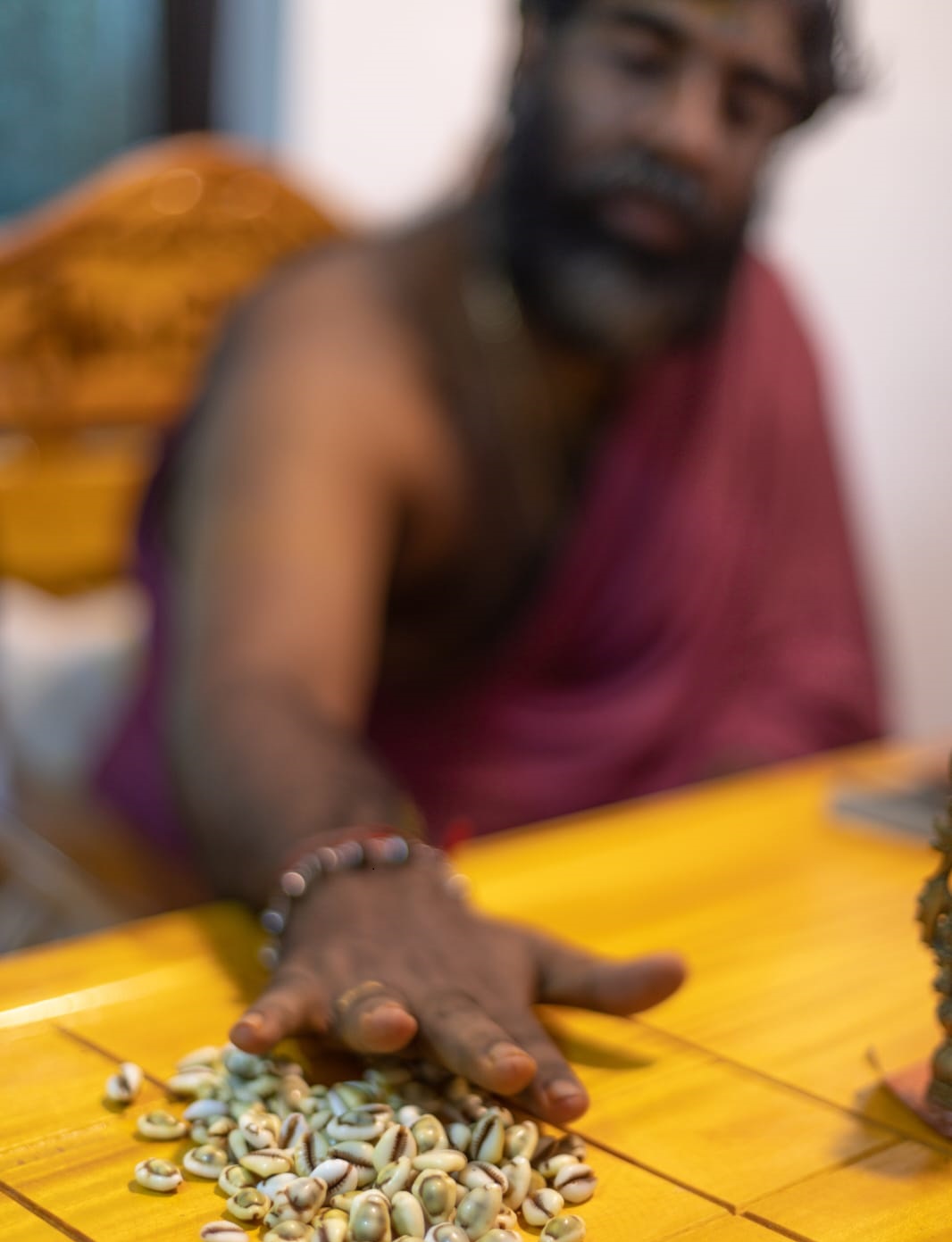 Jineshji performing prasnam — cowrie shell divination